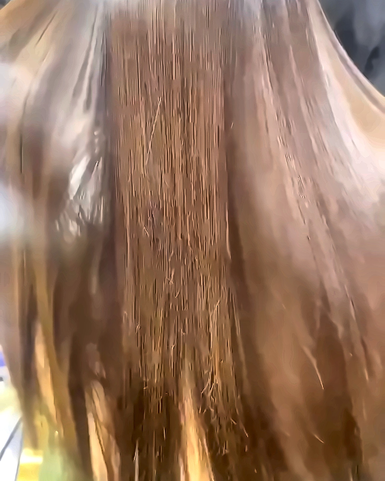 Freshly keratin-treated brown hair falling in a glossy, poker-straight sheet