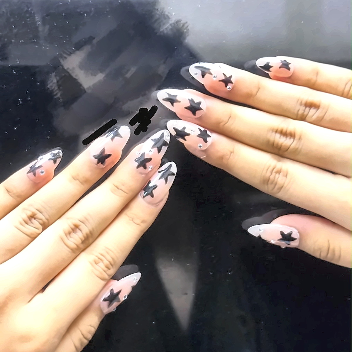 Nude gel nails with a hand-drawn star accent on the ring finger